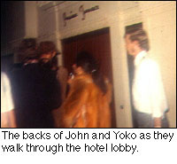 The backs of John and Yoko as they walk through the hotel lobby.